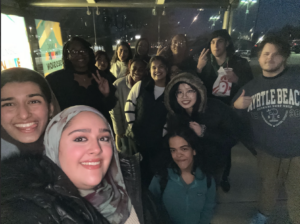 A group of Living Learning Community members take a selfie while waiting at the UMBC bus stop
